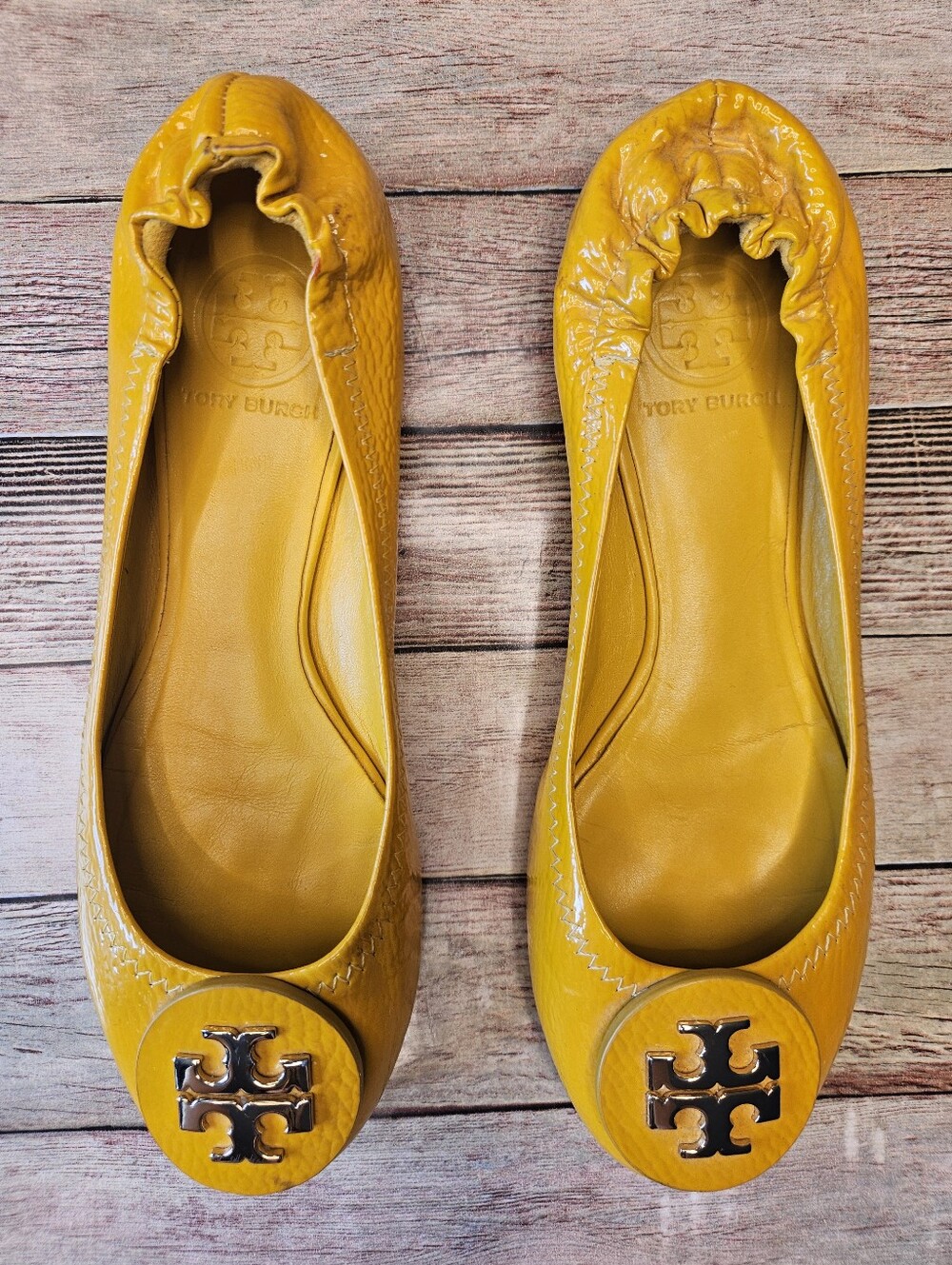 Tory Burch Reva patent leather ballet flats in mustard yellow.